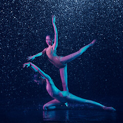 Image showing Two young female ballet dancers under water drops