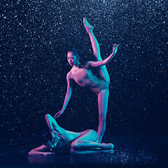 Image showing Two young female ballet dancers under water drops