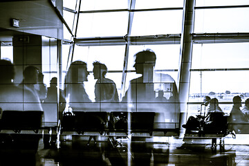 Image showing Silhouettes of business people traveling on airport waiting at the plane boarding gates