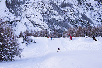 Image showing rescue team with a red helicopter rescuing a hurt skier