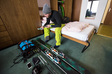 Image showing skier preparing ski accessories