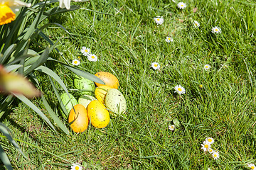 Image showing colored Easter eggs hidden in flowers and grass