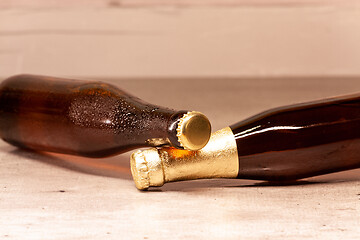 Image showing a bottle of blonde beer and a bottle of amber beer lying down