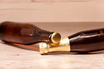 Image showing a bottle of blonde beer and a bottle of amber beer lying down