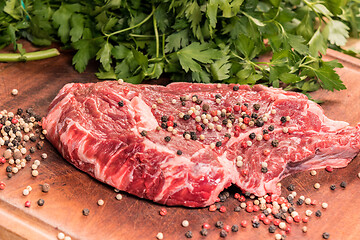 Image showing steak of beef on a wooden board with spices and parsley