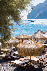 Image showing beach with umbrellas and deck chairs by the sea in Santorini