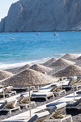 Image showing beach with umbrellas and deck chairs by the sea in Santorini