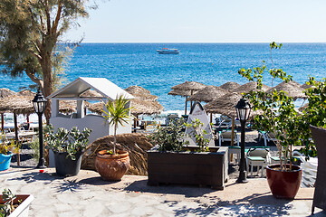 Image showing beach with umbrellas and deck chairs by the sea in Santorini