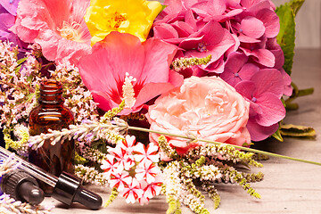 Image showing flowers and bottles of essential oils for aromatherapy