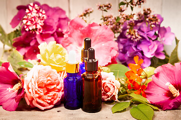 Image showing flowers and bottles of essential oils for aromatherapy