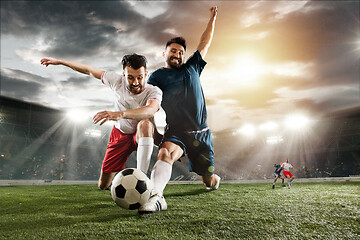 Image showing Two men are playing soccer and they compete with each other