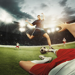 Image showing Two men are playing soccer and they compete with each other