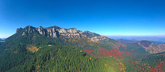 Image showing Aerial view of rocky mountain and colored forest