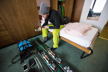 Image showing skier preparing ski accessories