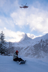 Image showing rescue team with a red helicopter rescuing a hurt skier