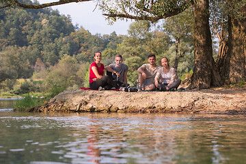 Image showing friends smoking hookah on the river bank