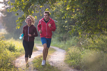 Image showing young couple jogging along a country road