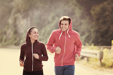 Image showing young couple jogging along a country road