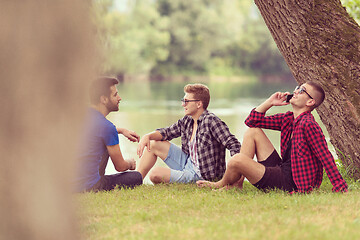 Image showing men sitting on the bank of the river