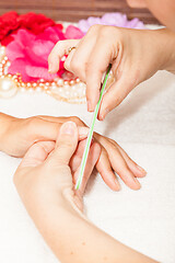 Image showing The beautician polish the client\'s nails before putting nail polish