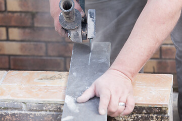 Image showing tiler cutting a tile with a grinder