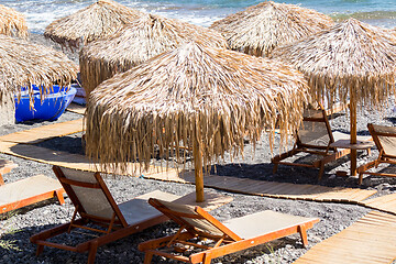 Image showing beach with umbrellas and deck chairs by the sea in Santorini