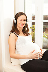 Image showing happy pregnant woman listening to music