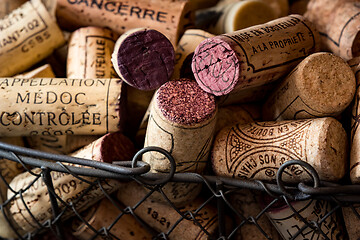 Image showing old cork stoppers of French wines in a wire basket