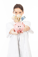 Image showing A woman shows a piggy bank full of European banknotes