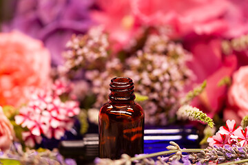 Image showing flowers and bottles of essential oils for aromatherapy