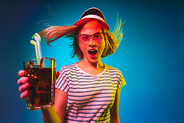 Image showing Beautiful woman in neon light isolated on blue studio background