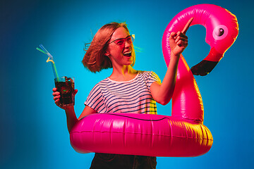 Image showing Beautiful woman in neon light isolated on blue studio background