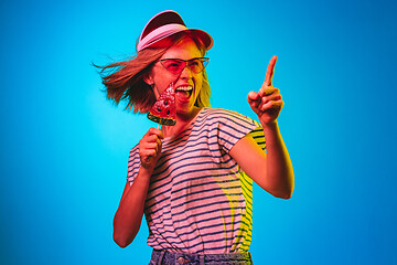 Image showing Beautiful woman in neon light isolated on blue studio background