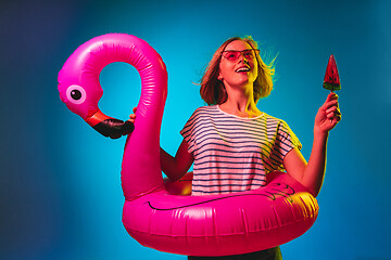Image showing Beautiful woman in neon light isolated on blue studio background