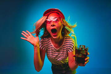 Image showing Beautiful woman in neon light isolated on blue studio background