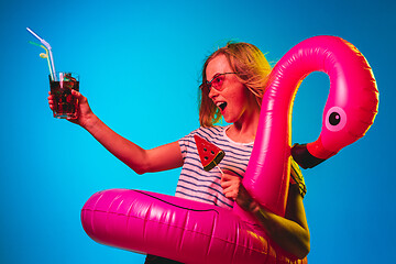 Image showing Beautiful woman in neon light isolated on blue studio background