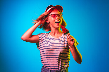 Image showing Beautiful woman in neon light isolated on blue studio background