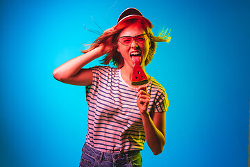 Image showing Beautiful woman in neon light isolated on blue studio background