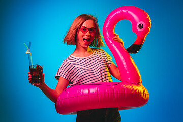 Image showing Beautiful woman in neon light isolated on blue studio background