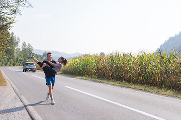 Image showing happy couple jogging along a country road