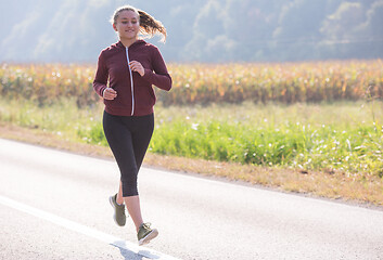 Image showing woman jogging along a country road