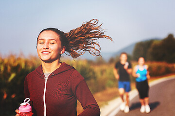 Image showing young people jogging on country road