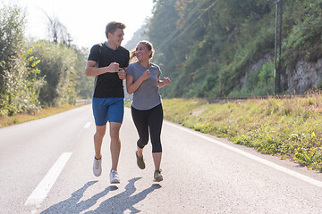 Image showing young couple jogging along a country road