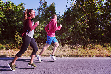 Image showing young couple jogging along a country road