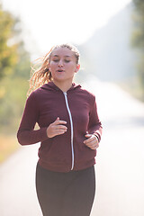 Image showing woman jogging along a country road