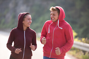 Image showing young couple jogging along a country road