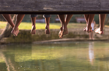 Image showing people sitting at wooden bridge