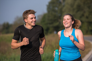 Image showing young couple jogging along a country road