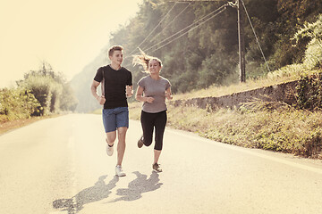 Image showing young couple jogging along a country road