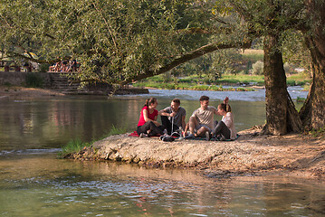 Image showing friends smoking hookah on the river bank